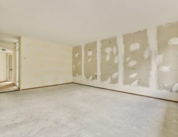 Plastic window and radiator on white wall in empty light room at home